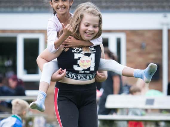 Winslow Big Society Summer Playscheme held at the recreation ground - pictured is Sophia Gibbard-Gill, eight, getting a piggyback from Remmini Jai-Rowlands, eight (dressed in black)