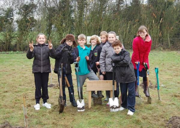 Year 6 pupils from Longwick Church of England Combined School planting trees at the Aylesbury Burial Meadow