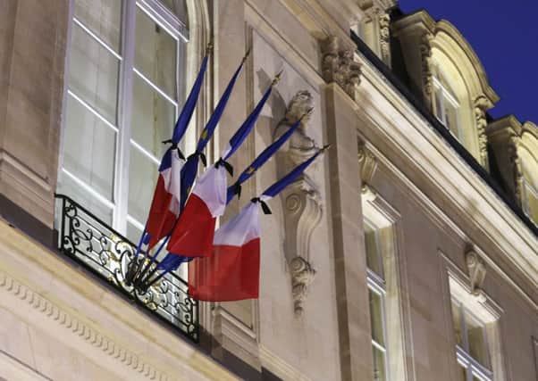 Flags are tied up with black ribbons as French President Francois Hollande meets with government members at the Elysee Palace in Paris after the terrorist attack against satirical newspaper Charlie Hebdo. AP Photo/Remy de la Mauviniere