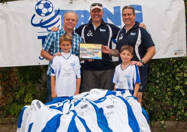 Derek Williams, Greg Cox (director of Tring Tornadoes Charity) and Stephen Bailey join young Tornadoes players in making the kit donation. Picture (c) Vanessa Champion