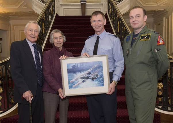 Arnold and Hilary Tasker, left, present a painting of a Vickers Vimy aircraft to Station by Wing Commander Ray Morley and Squadron Leader Gary Coleman at RAF Halton