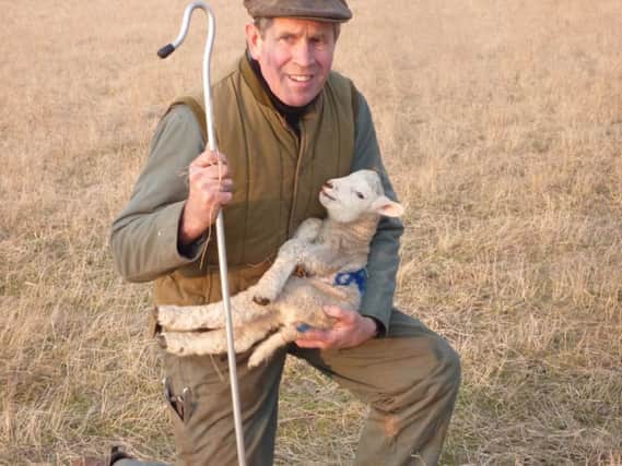 Farmer Geoff Brunt with a new born lamb