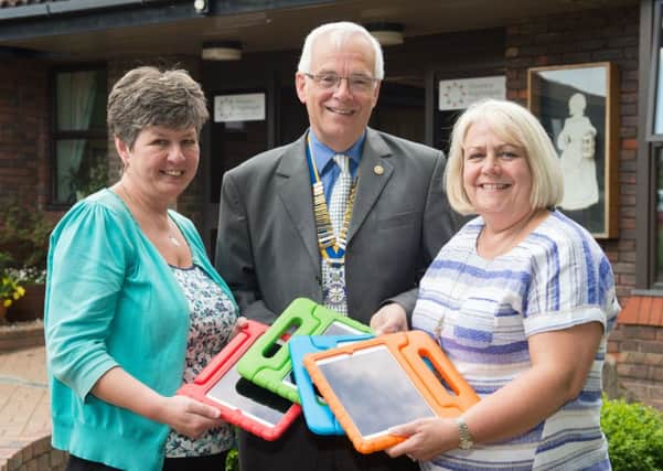 David Sibthorp, chairman of Winslow Rotary, presents iPads to Florrie's team leader Angie Pestka, left and FNHC executive director Sue Jenkins, right