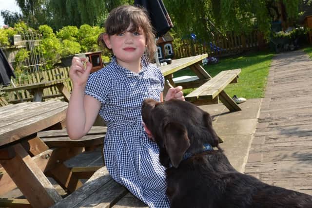 Maisie Chapman from Buckingham wth Rolo the dog who survived eating a glove!