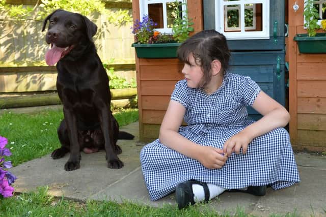 Maisie Chapman from Buckingham wth Rolo the dog who survived eating a glove!
