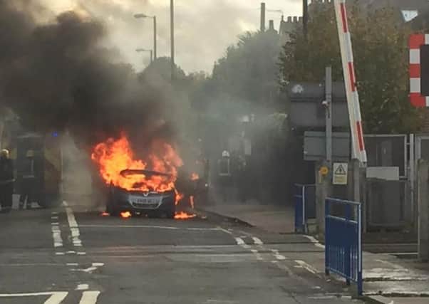 Firefighters extinguish a Vauxhall Zafira which caught light. PHOTO: PRESS ASSOCIATION