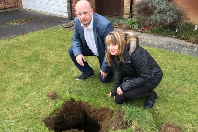 Kynaston Avenue Stoke Mandeville. Emma James and councillor Marcus Rogers peer into a deep hole, with steps, which has appeared in Emma's garden PNL-160703-171407001