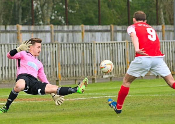 Zaki Oualah makes a fine save from Matt Woods. Picture by Mike Snell