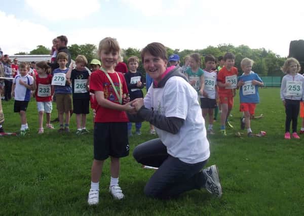 Prestwood 10k and children's races - Cleo Cartledge, reception age winner, receives her medal from Hannah Asquith.