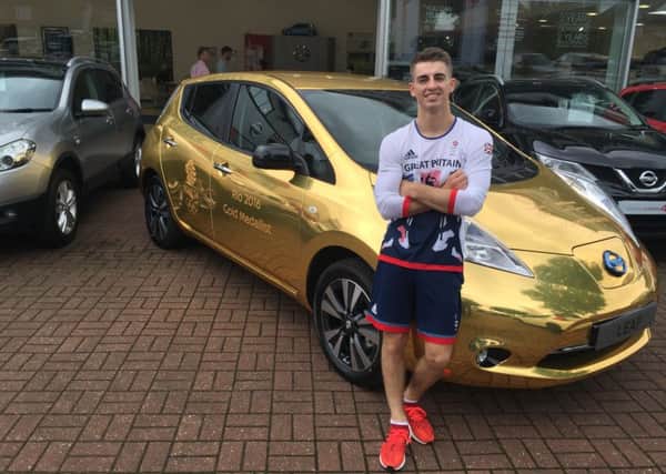 Olympic hero Max Whitlock with his electric Nissan Leaf, outside Aylesbury Nissan