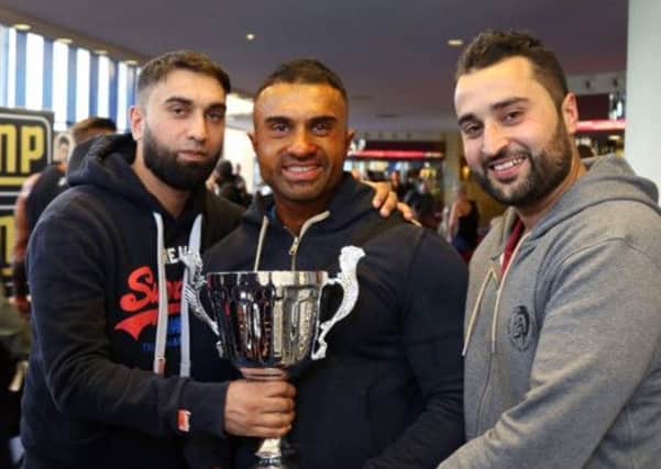 Sirtaj Rahman (centre) with the trophy after finishing fourth in the bodybuilding competition