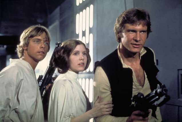 Actors, from left, Mark Hamill as Luke Skywalker, Carrie Fisher as Princess Leia and Harrison Ford as Han Solo, appear in a scene from Lucasfilm's "Star Wars: Episode IV, A New Hope," in this undated promotional photo. Lucasfilm Ltd. and 20th Century Fox announced Tuesday, Feb. 10, 2004, that the original three "Star Wars" films will be released on DVD on Sept. 21, 2004, in North America. (AP Photo/Lucasfilm, Ltd. & TM) LA102
